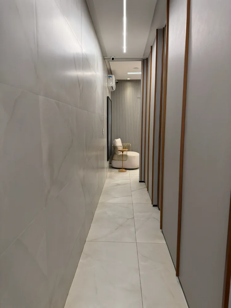Corredor em mármore com poltrona ao fundo